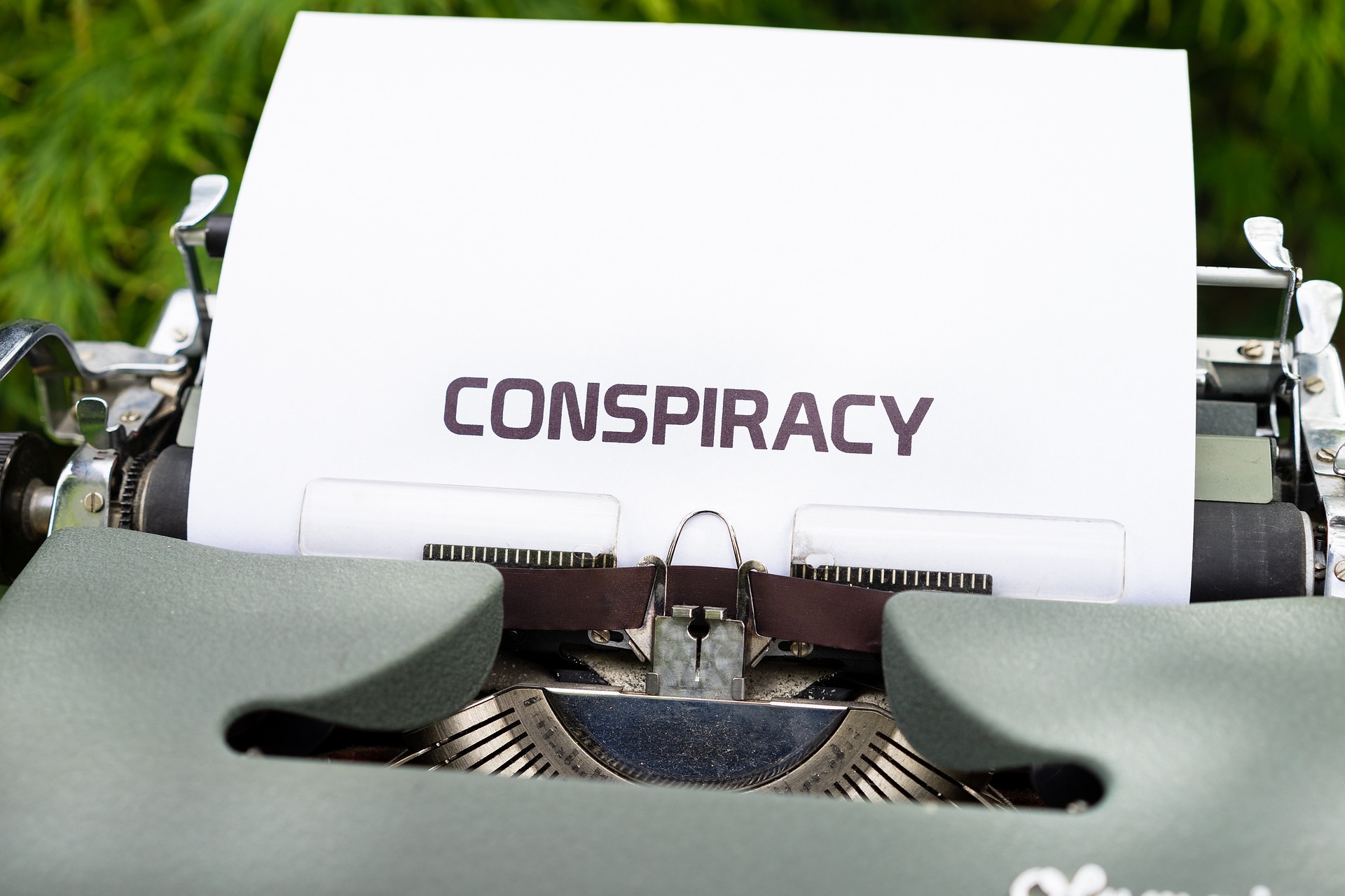 Eine Schreibmaschine mit dem Schriftzug Conspiracy (Englisch für Verschwörung)