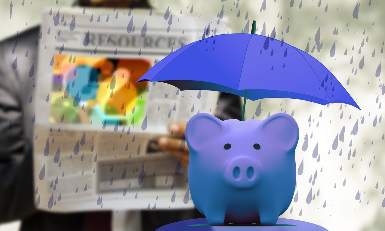 Ein blaues Sparschwein steht im Regen..