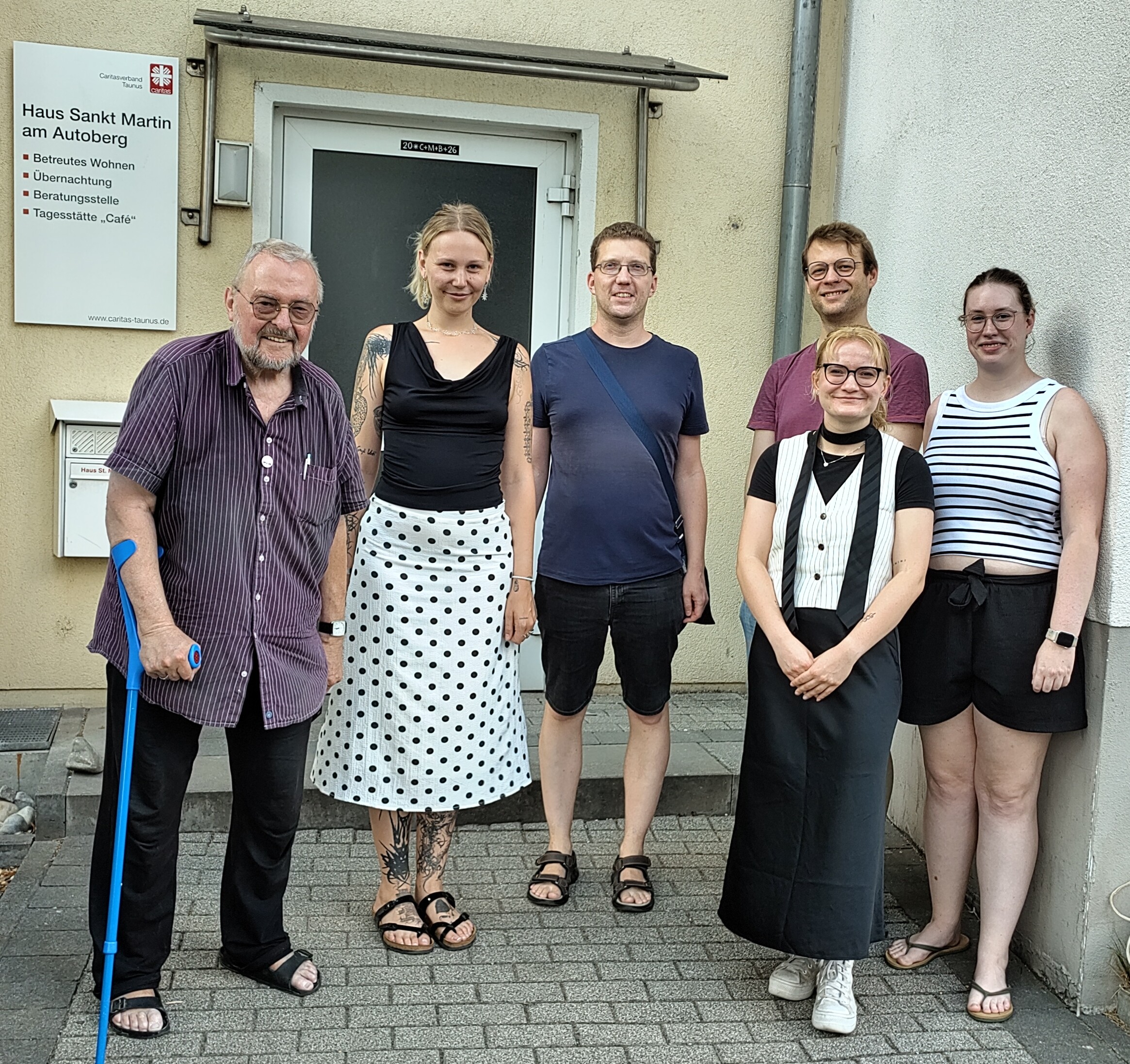 Vor der Wohnungsloseneinrichtung St. Martin am Autoberg stehen drei Männer und dfrei Frauen im Gruppenbild.